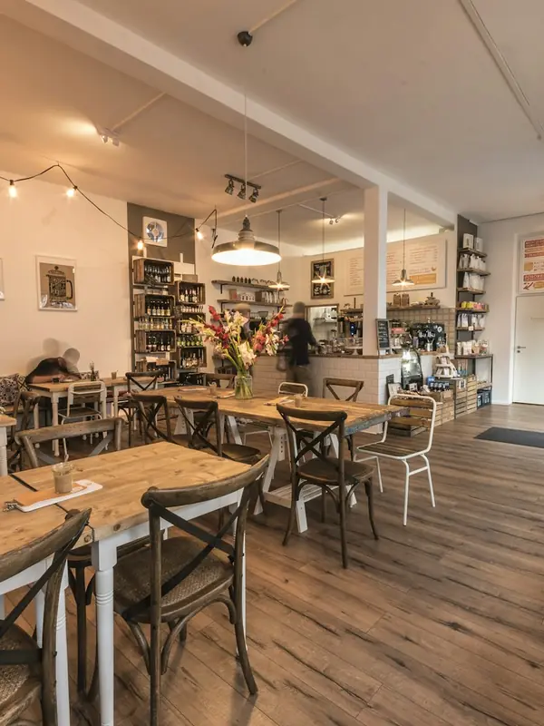 Helles Café mit Holztischen und Tresen